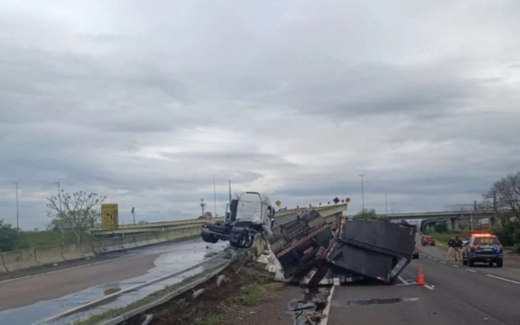 Caminhão tomba em acesso da BR-116 à BR-290 BR-290 foi palco de mais um acidente, quando um caminhão tombou por volta das 8h05 deste domingo (28), na alça de acesso da BR-116, no km 270, em Porto Alegre, na ligação com a freeway em direção ao Litoral Norte. Segundo informações da Polícia Rodoviária Federal (PRF), o veículo tombou no sentido Litoral, provocando o bloqueio parcial da pista e afetando o tráfego na região. Motorista sofreu ferimentos leves O motorista do caminhão, cuja identidade não foi divulgada, sofreu apenas ferimentos leves. Ele recebeu atendimento ainda no local do acidente por equipes de socorro e não corre risco de vida. Apesar do susto, não houve necessidade de remoção hospitalar imediata. Trânsito lento e bloqueio parcial no acesso à freeway De acordo com a PRF, uma das faixas segue bloqueada no acesso à BR-290, e os motoristas enfrentam lentidão no trecho. Agentes da corporação permanecem no local realizando o atendimento da ocorrência e orientando o fluxo de veículos. Ainda não há previsão para a liberação total da pista, já que será necessária a remoção do caminhão e a limpeza da via. Acidentes recorrentes na região da BR-116 e BR-290 A alça de acesso entre a BR-116 e a BR-290 é conhecida pelo fluxo intenso, principalmente em horários de pico e em períodos de deslocamento para o Litoral. Tombamentos e colisões são registrados com frequência no entroncamento, considerado um ponto crítico do tráfego em Porto Alegre. Especialistas alertam para a necessidade de maior atenção dos motoristas ao fazer curvas acentuadas com veículos de carga pesada. O que se sabe até agora Caminhão tombou por volta das 8h05. Local: alça de acesso da BR-116 ao km 270 da BR-290 (freeway). Motorista teve ferimentos leves e foi atendido no local. Uma faixa segue bloqueada, com trânsito lento no sentido Litoral. PRF atende a ocorrência e fará remoção do veículo.