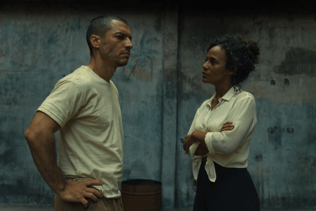 Homem e mulher conversando frente a frente em ambiente fechado