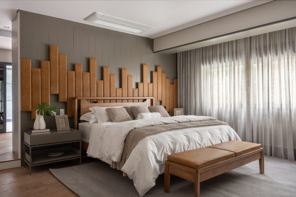 imagem de quarto com cama de madeira com edredom branco com cabeceira de couro marrom e parede cinza