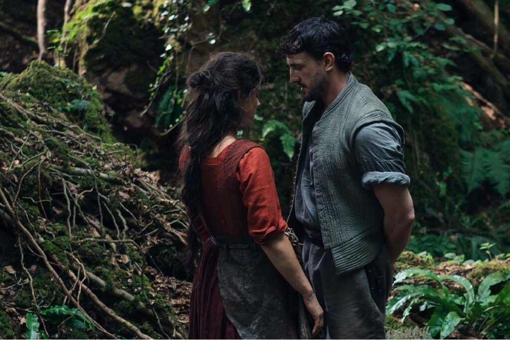 Oscar 2026: 5 filmes que você precisa assistir antes da premiação 21 Cena do filme "Hamnet - A Vida Antes de Hamlet" , com um casal um de frente para o outro em uma floresta